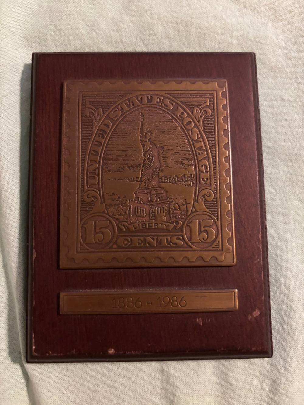 liberty Bronze-Tone Stamp Plaque on Brown Wood